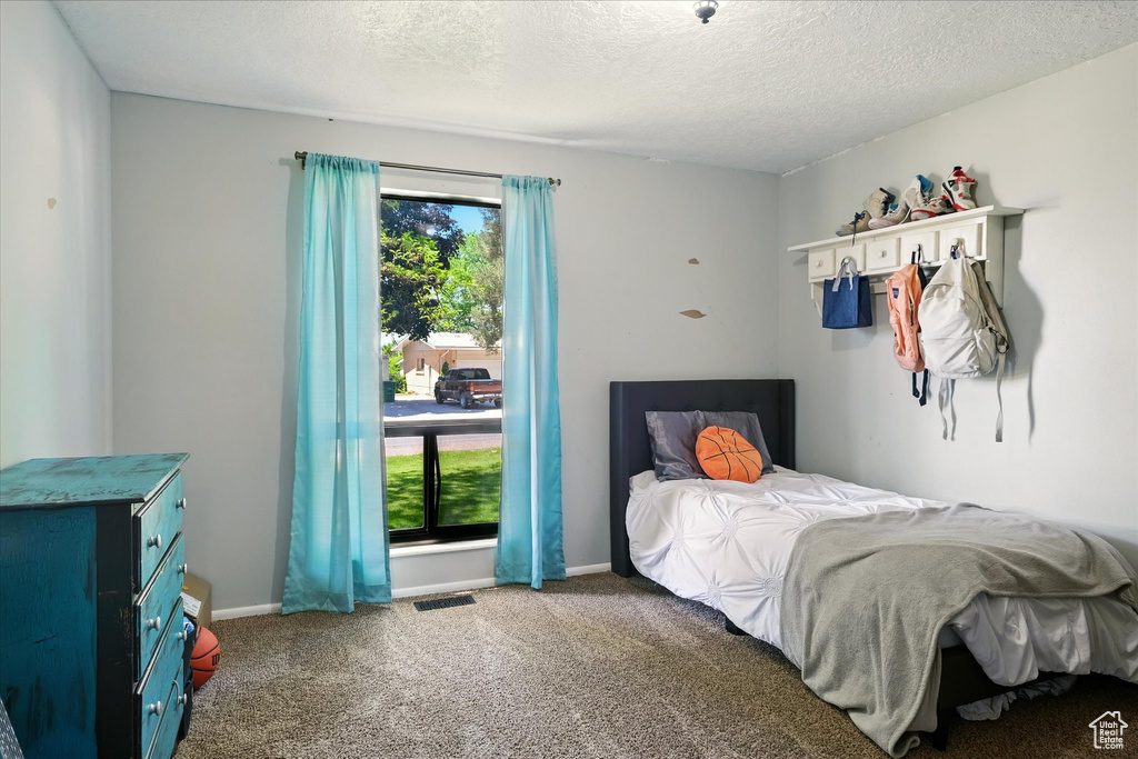 Bedroom with carpet and a textured ceiling