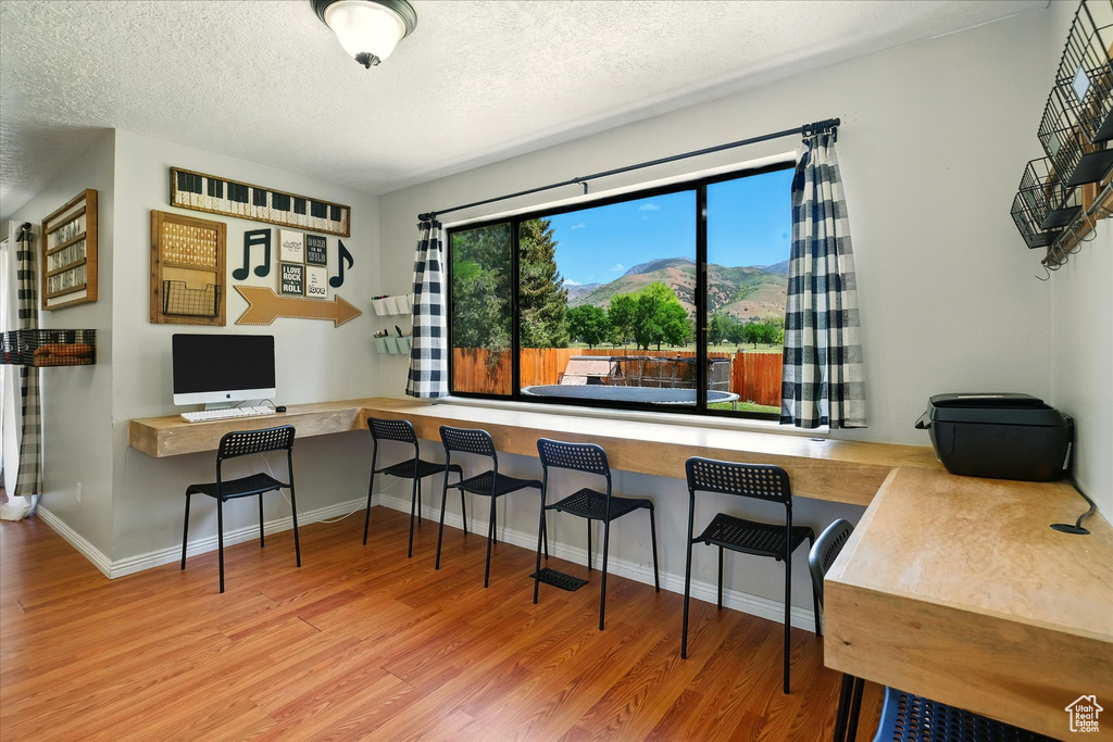 Home office with wood finished floors and a textured ceiling