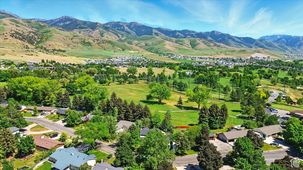 Aerial view of property and surrounding area with a mountain backdrop and nearby suburban area