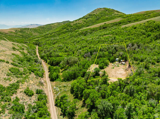 Aerial overview of property's location with property boundaries highlighted and a mountainous background