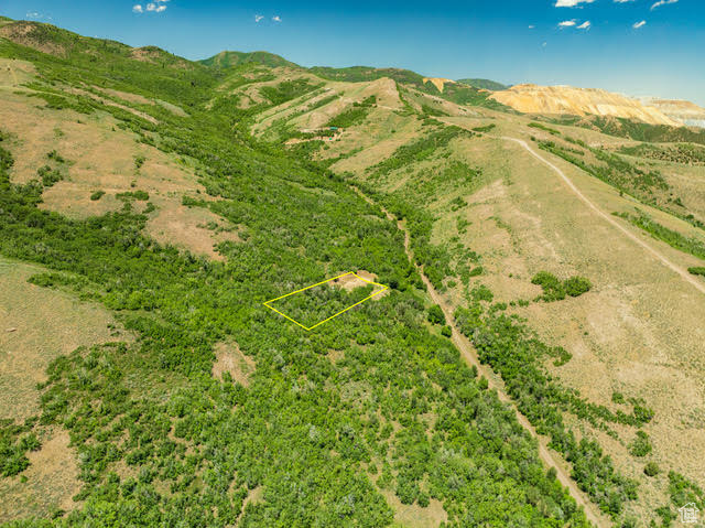 Aerial view of property's location with property boundaries highlighted and a mountain backdrop