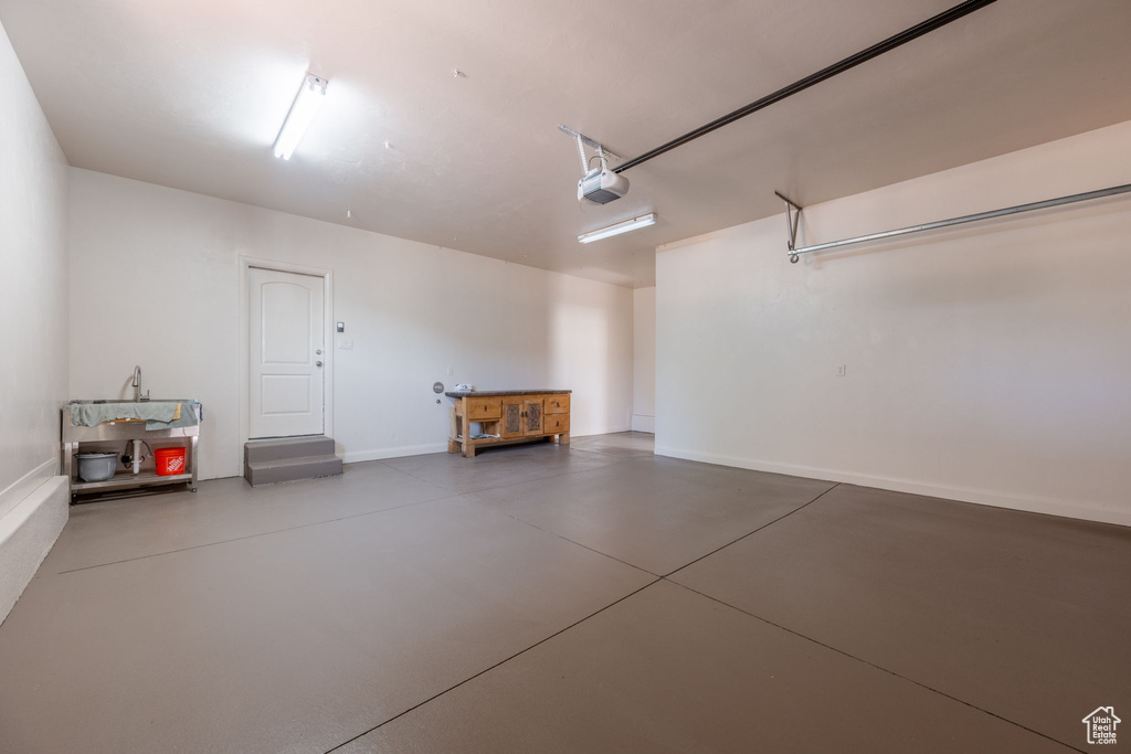 Garage with a garage door opener and baseboards