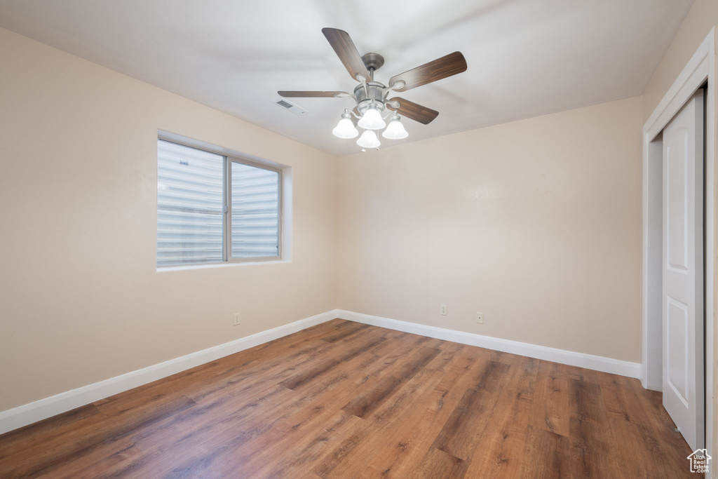 Unfurnished bedroom with a closet, wood finished floors, and a ceiling fan