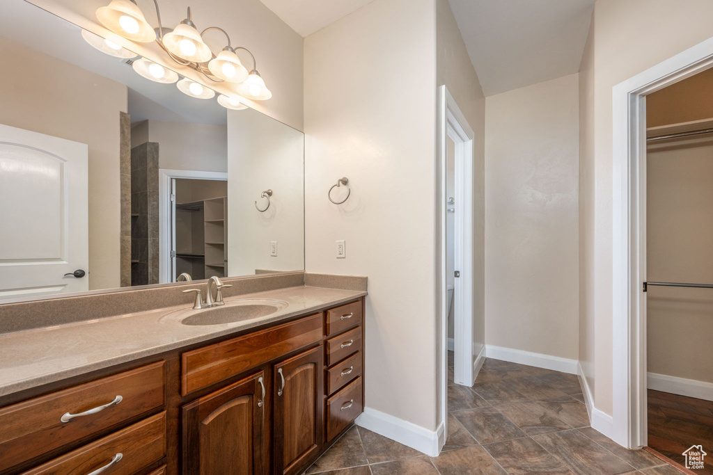 Full bathroom featuring a walk in closet and vanity