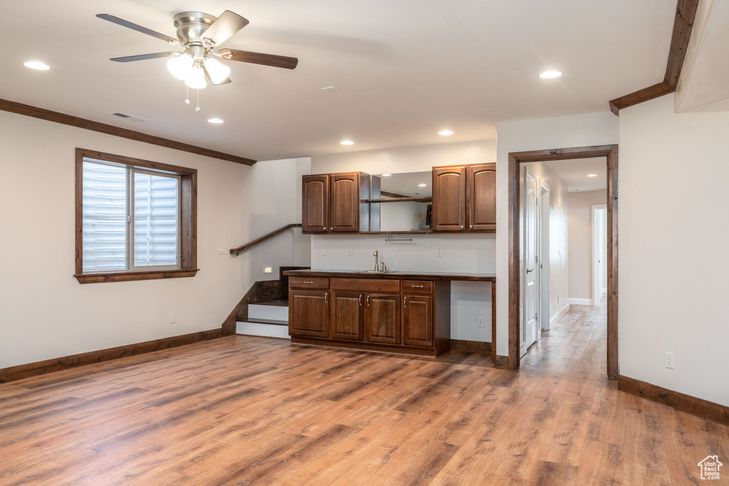 Kitchen featuring ceiling fan, open shelves, light wood-style floors, recessed lighting, and crown molding