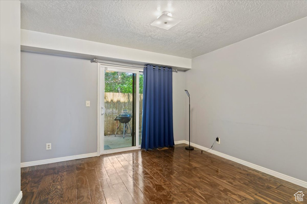 Spare room featuring a textured ceiling and wood finished floors