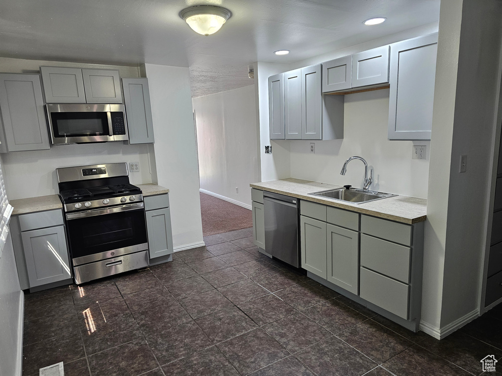 Kitchen featuring appliances with stainless steel finishes, gray cabinets, light countertops, and recessed lighting