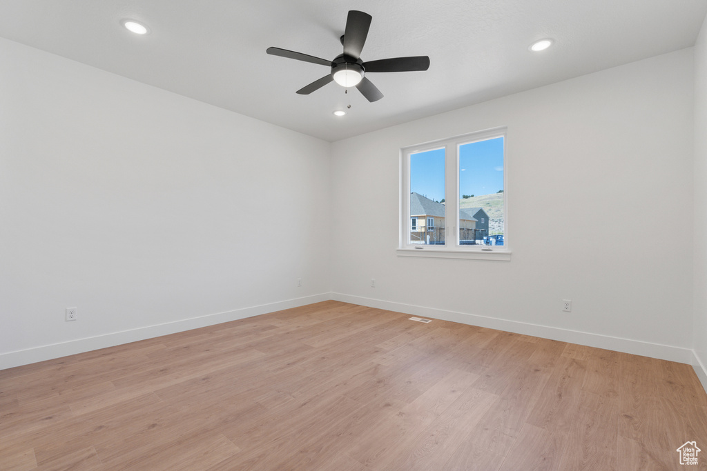 Spare room featuring light wood finished floors, ceiling fan, and recessed lighting