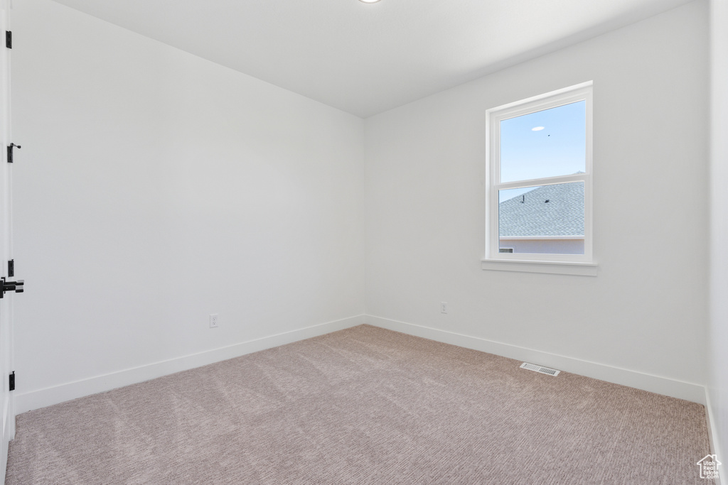 Spare room with light colored carpet and baseboards