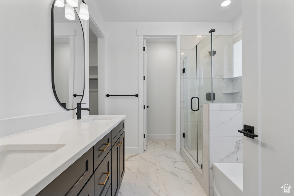 Bathroom with marble finish flooring, double vanity, a stall shower, recessed lighting, and a bath