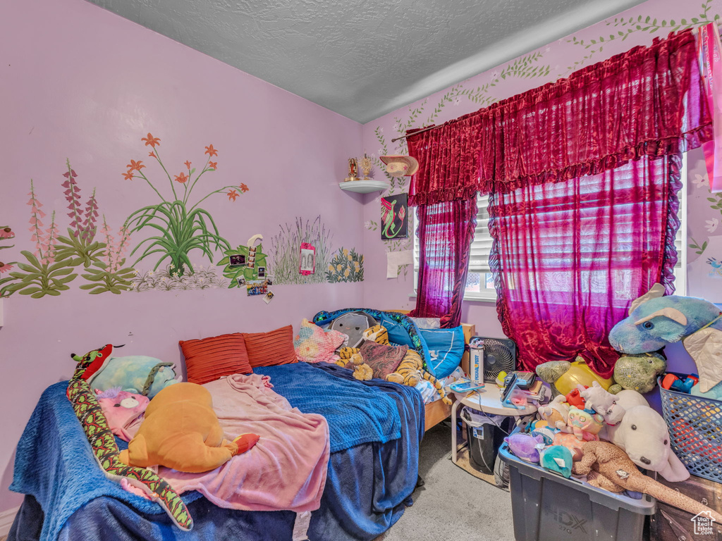 Bedroom with carpet and a textured ceiling
