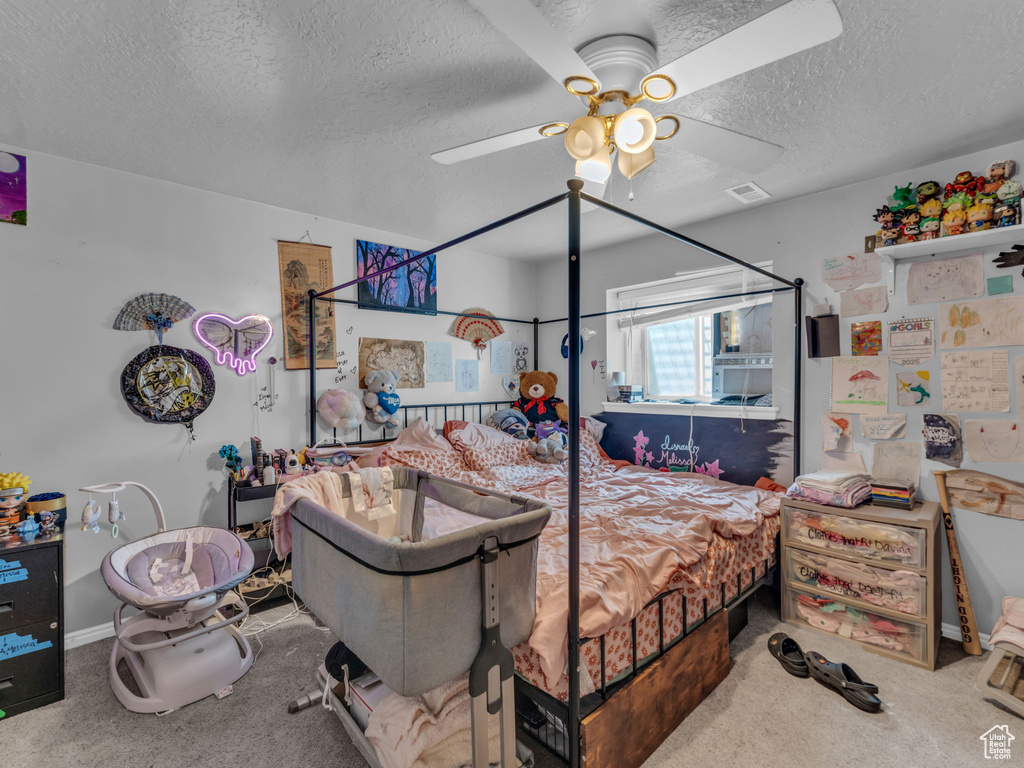 Bedroom with carpet flooring, a textured ceiling, and a ceiling fan