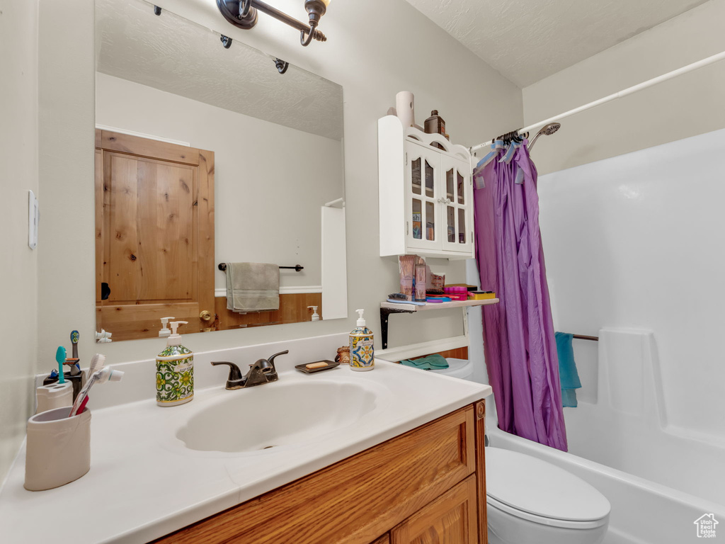 Bathroom featuring vanity and shower / bathtub combination with curtain