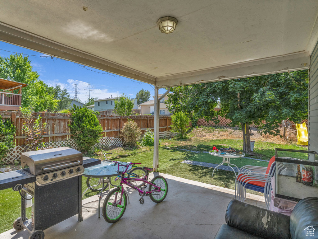 Fenced backyard with a patio and a grill