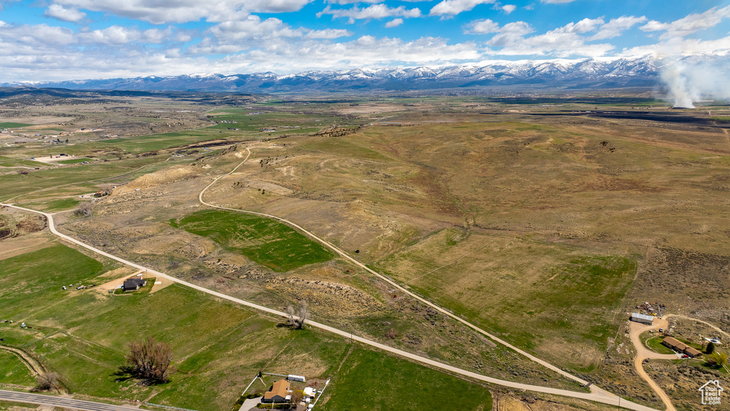 Aerial view of property and surrounding area with mountains, rural landscape, and property parcel outlined