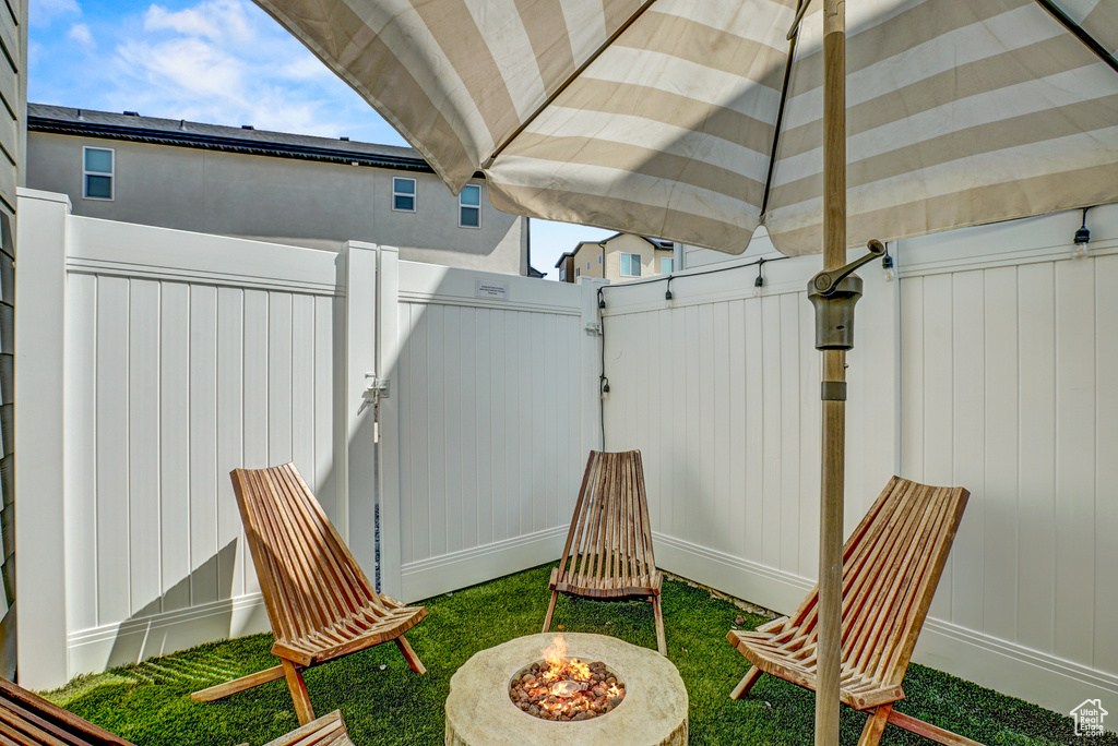 View of patio featuring a fire pit and a gate