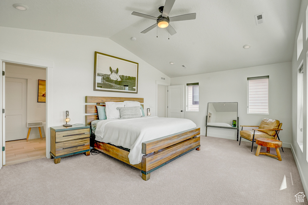 Bedroom featuring vaulted ceiling, light colored carpet, and ceiling fan