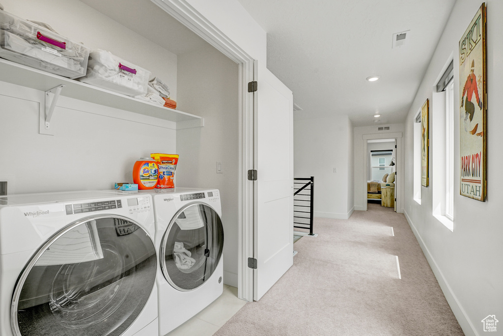 Laundry room with separate washer and dryer, light colored carpet, and recessed lighting