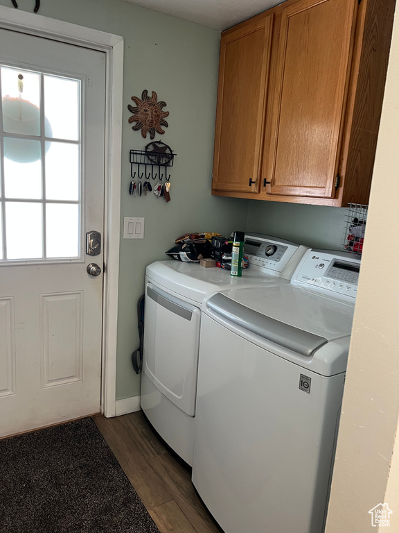 Laundry room with separate washer and dryer, cabinet space, and wood finished floors