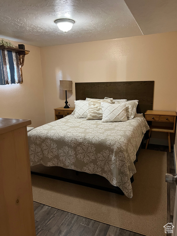 Bedroom featuring wood finished floors and a textured ceiling