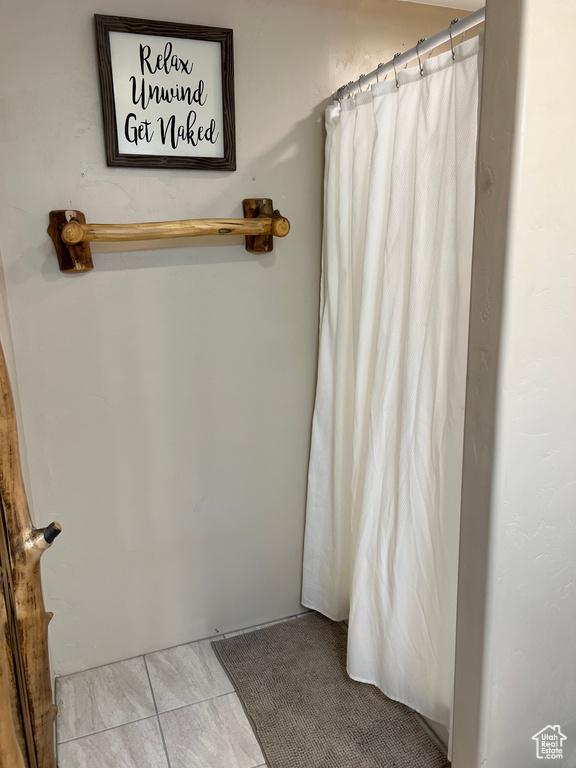 Full bathroom featuring tile patterned flooring and a shower with shower curtain