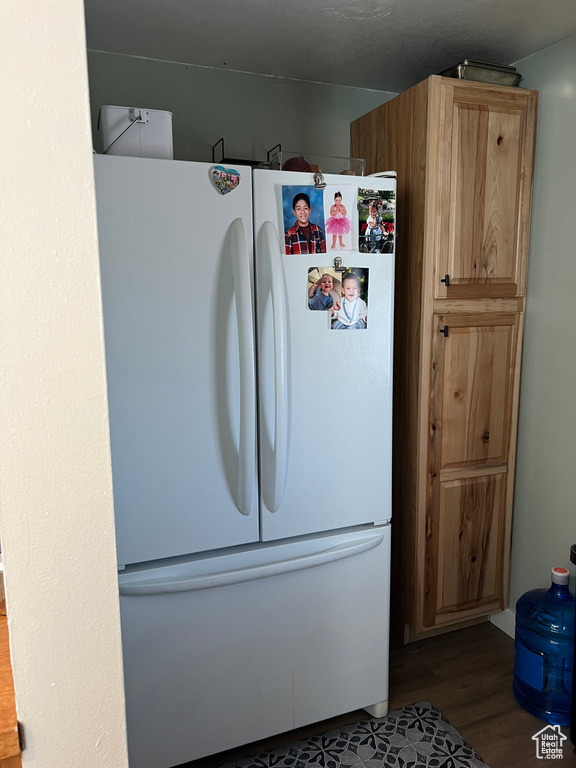 Kitchen with freestanding refrigerator and wood finished floors