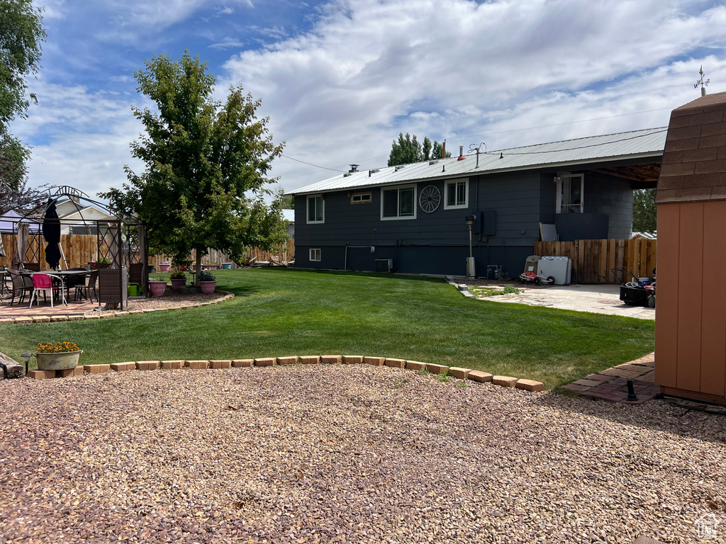Rear view of property with a gazebo, a patio, and a metal roof