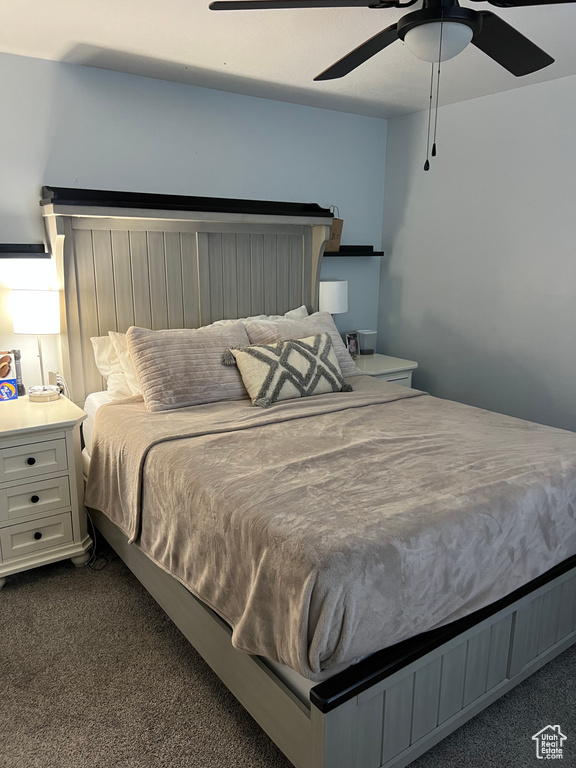 Bedroom with dark colored carpet and ceiling fan