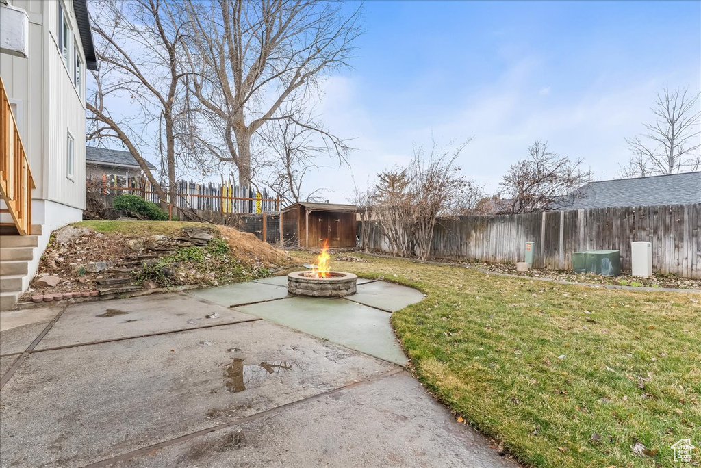 Fenced backyard featuring an outdoor fire pit and a patio
