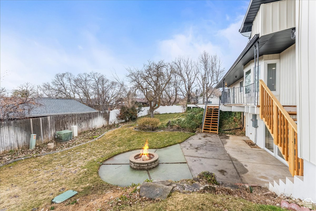 Fenced backyard featuring stairway, an outdoor fire pit, a patio area, and a deck