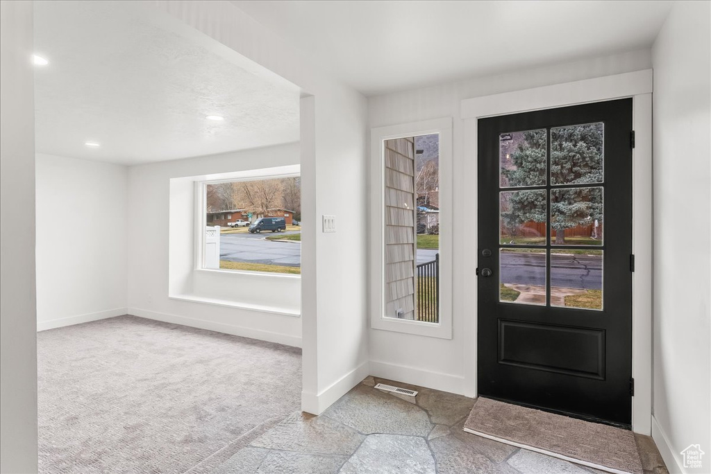 Carpeted entryway featuring plenty of natural light and recessed lighting