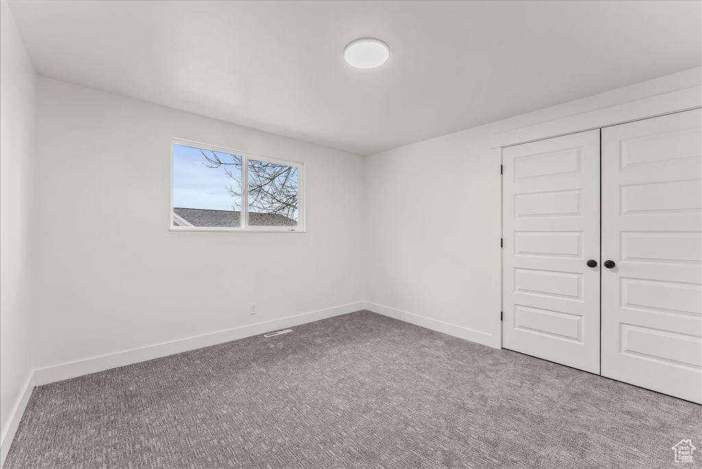 Unfurnished bedroom with carpet flooring and a closet