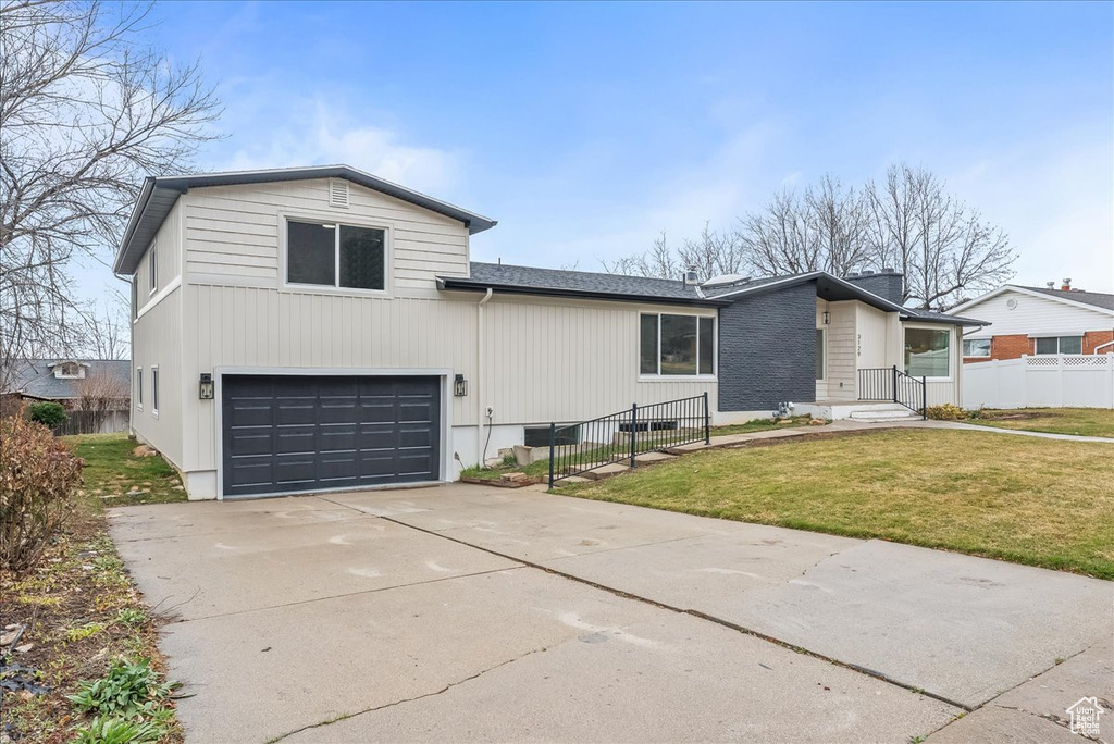 View of front of property with a garage and concrete driveway