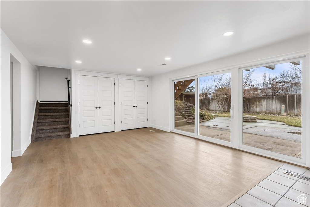 Unfurnished living room featuring recessed lighting, stairway, and wood finished floors