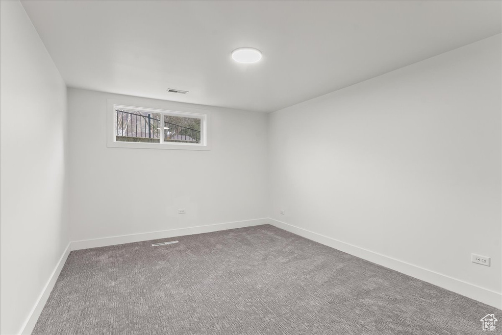 Carpeted spare room featuring baseboards