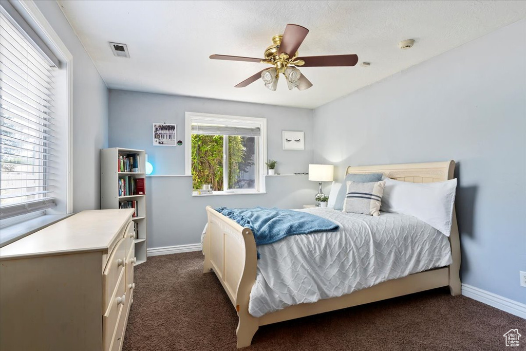 Bedroom with dark carpet and ceiling fan