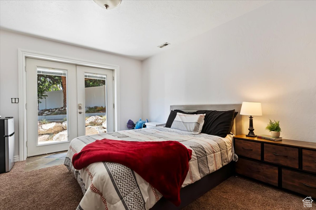 Bedroom featuring access to outside, carpet, and freestanding refrigerator
