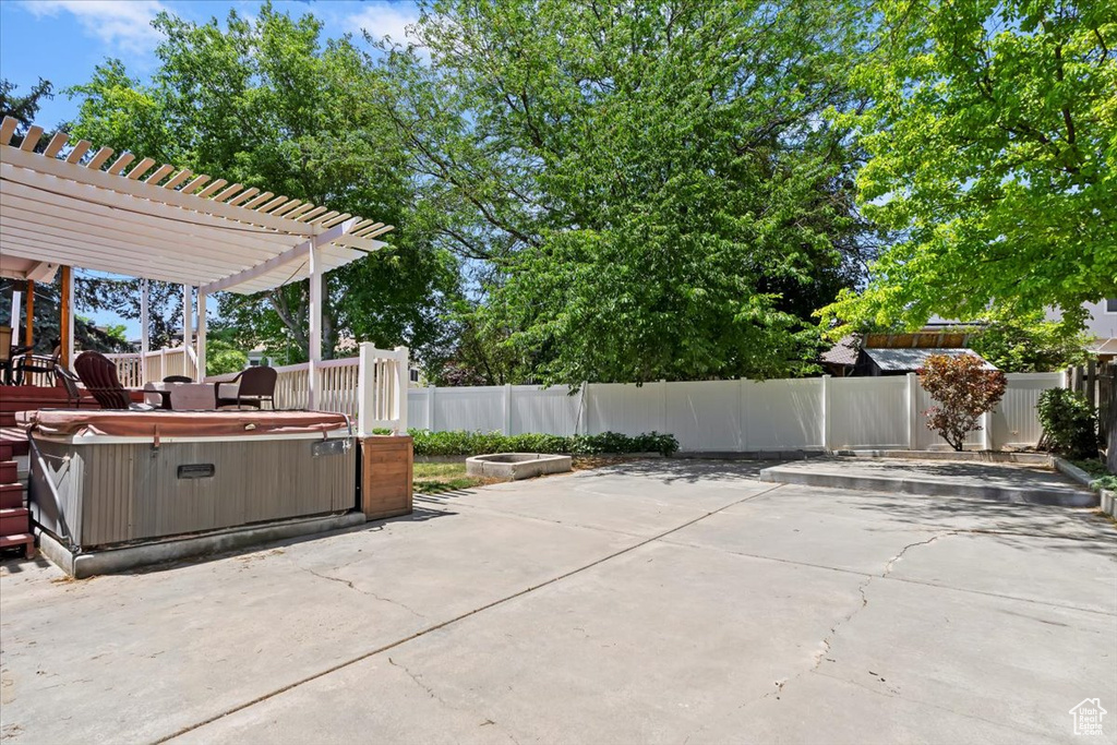 Fenced backyard featuring a hot tub, a patio area, and a pergola