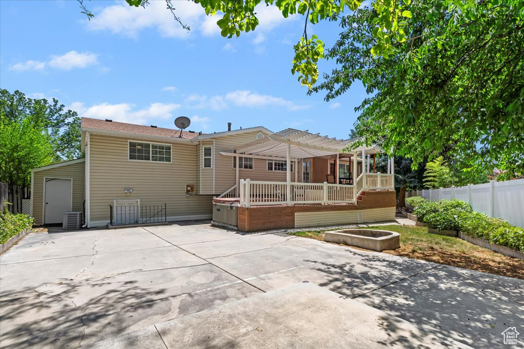 Rear view of property with a patio area, a pergola, a deck, and driveway