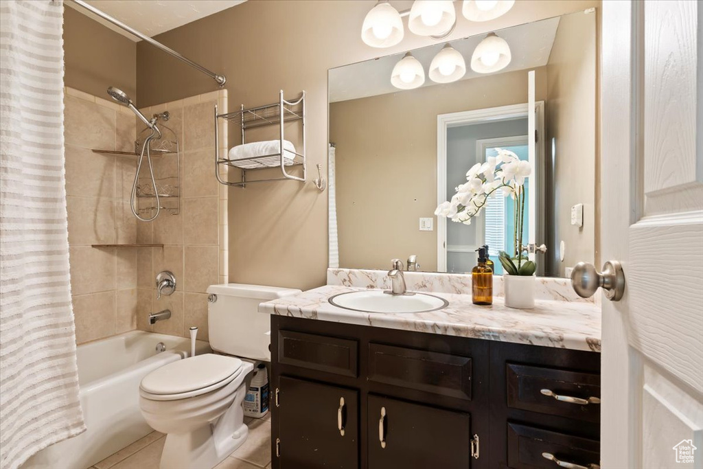 Full bath featuring shower / bath combo with shower curtain, vanity, and tile patterned flooring