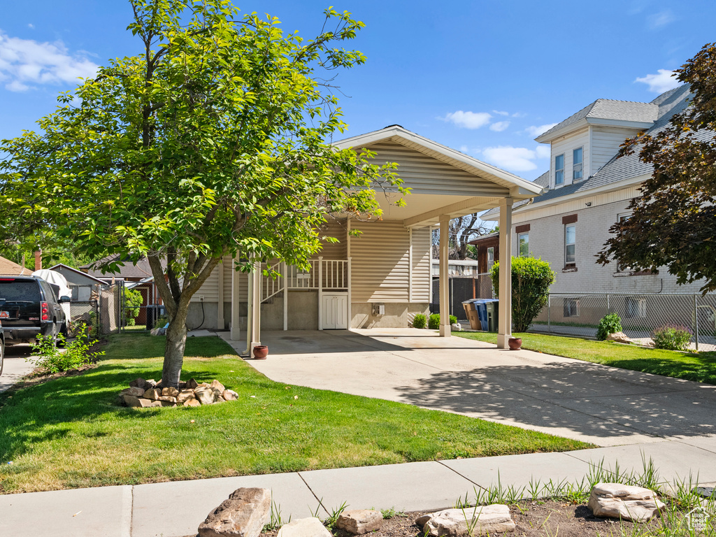View of front facade featuring concrete driveway and a front lawn