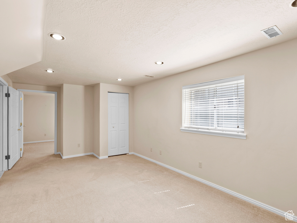 Unfurnished room featuring light carpet, recessed lighting, and a textured ceiling