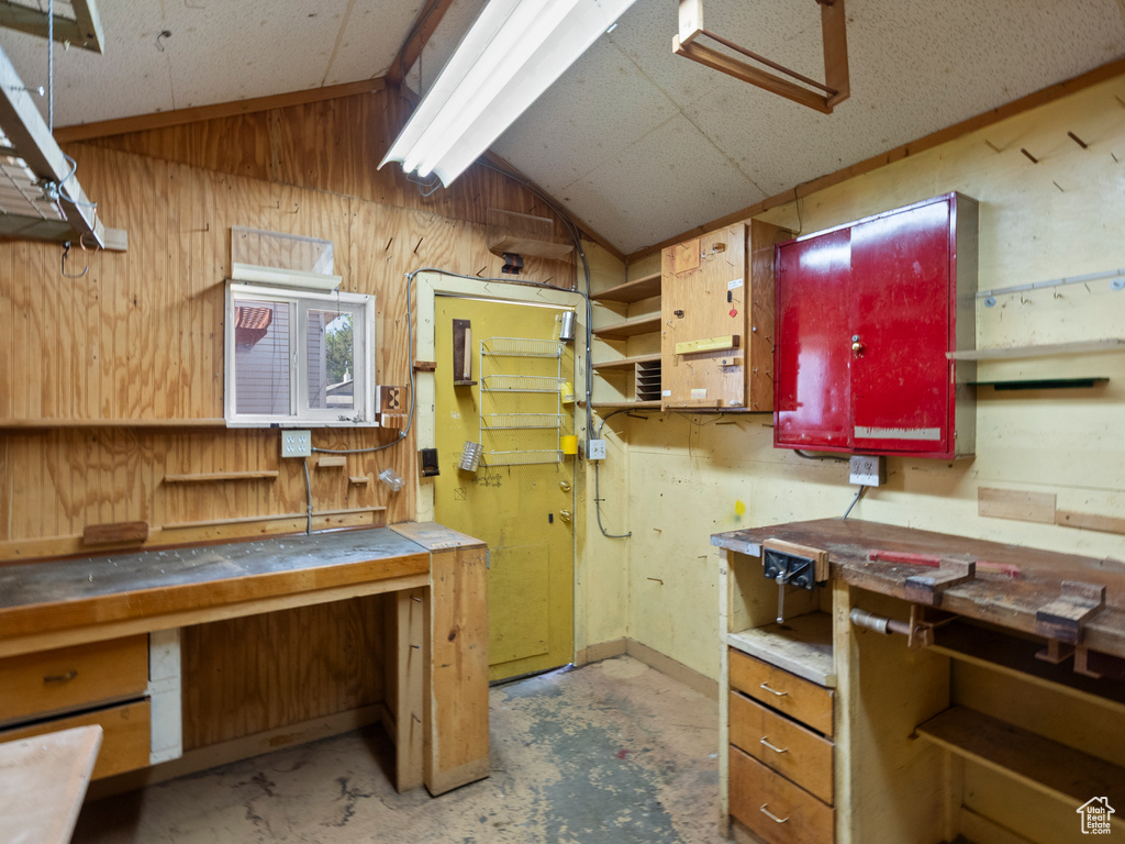 Kitchen featuring lofted ceiling, wood walls, and open shelves