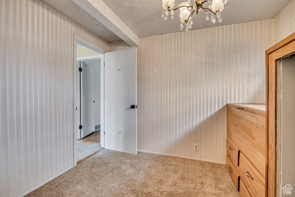 Empty room with carpet and a chandelier