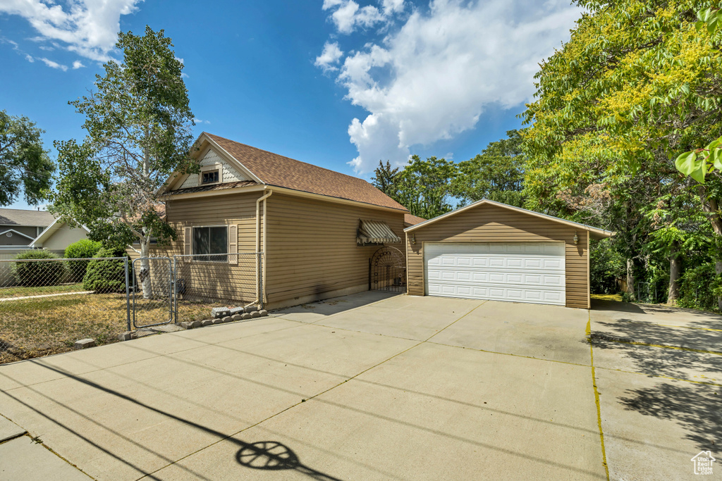 View of front of property with a detached garage and an outdoor structure