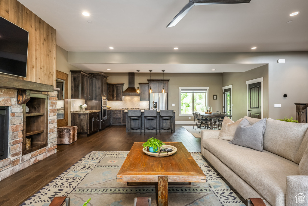 Living area featuring dark wood-style flooring, a fireplace, and recessed lighting