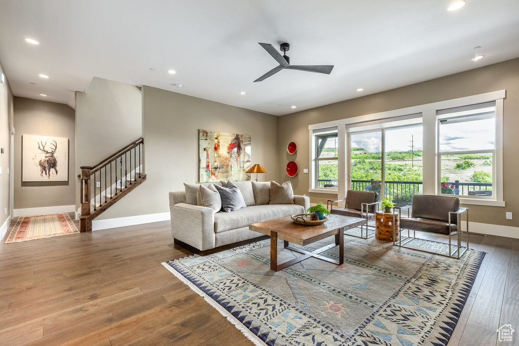 Living area with stairs, wood-type flooring, a ceiling fan, and recessed lighting