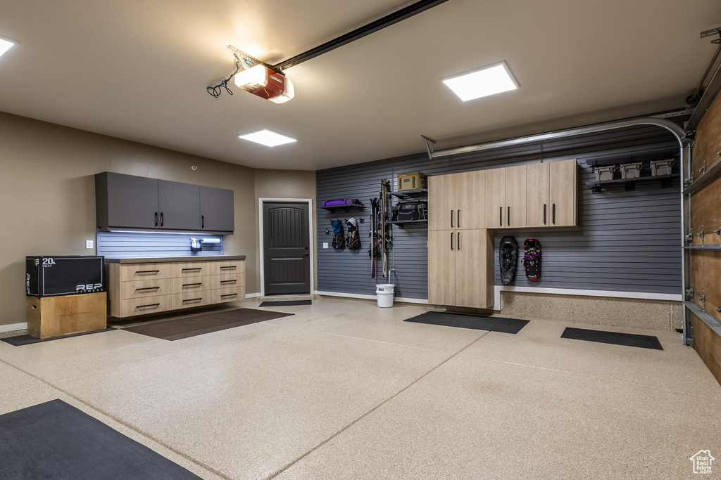 Garage with baseboards and a garage door opener