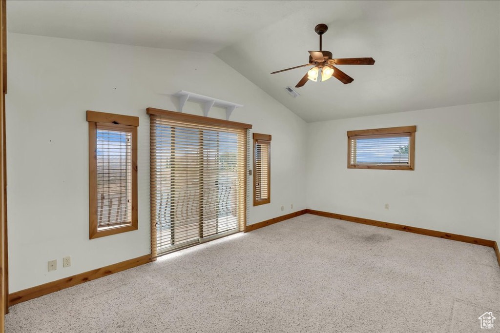 Carpeted spare room with lofted ceiling and ceiling fan