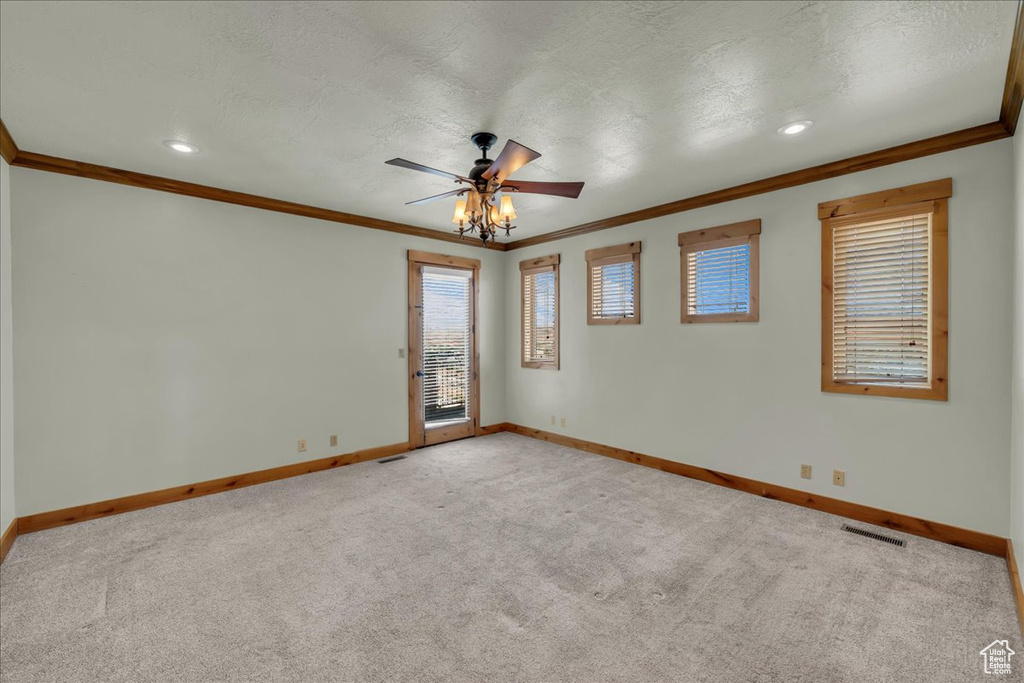 Spare room with ornamental molding, ceiling fan, light carpet, a textured ceiling, and recessed lighting